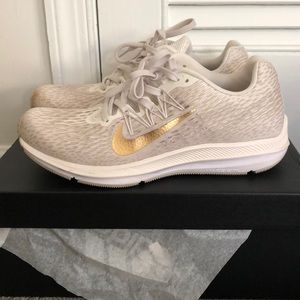 White and gold Nike running shoes